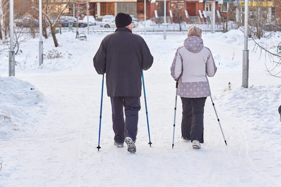 Seniorzy trenujący nordic walking zimą